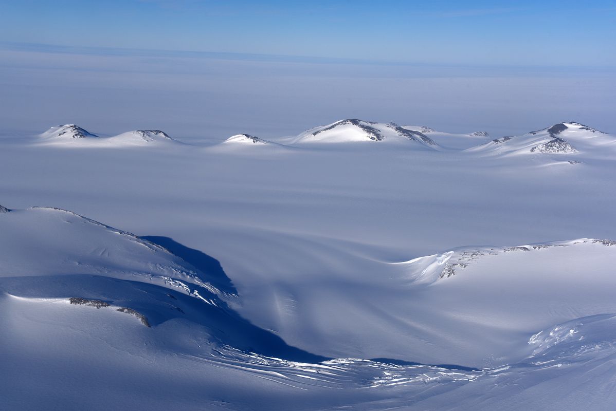 04D Small Mountains Pop Up From The Surrounding Glacier From Airplane Flying From Union Glacier Camp To Mount Vinson Base Camp